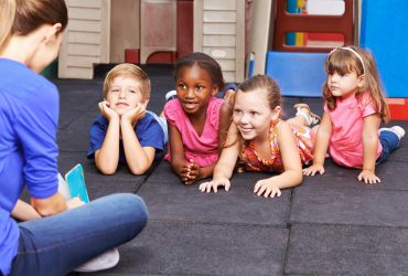 Kindergrtnerin liest Kindern Buch vor